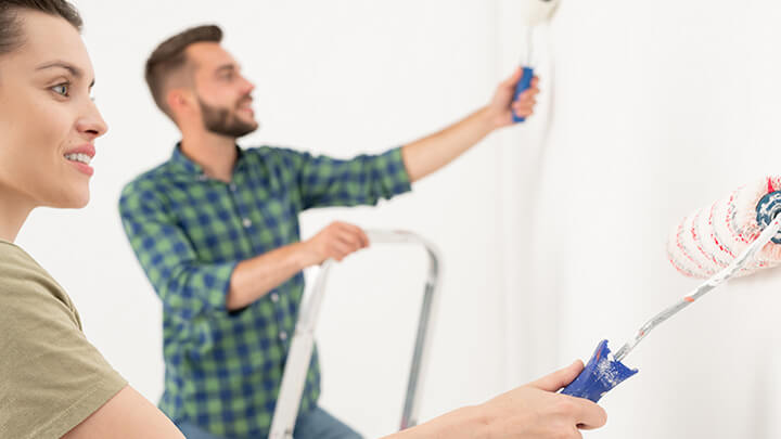 A couple painting a room.